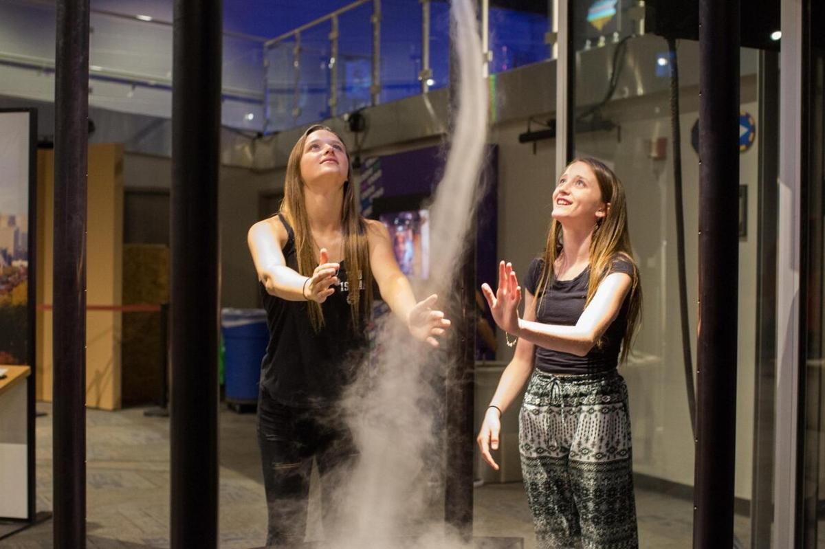 two women standing in front of a smoke machine