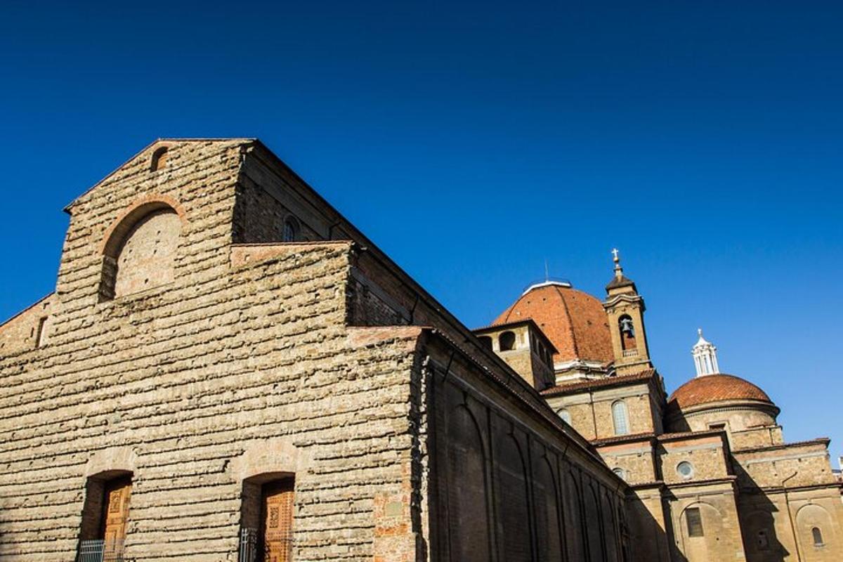 an old brick building with a church in the background