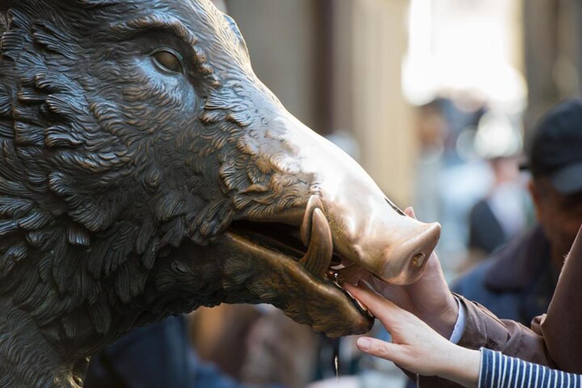 una persona che dà da mangiare alla statua di un orso