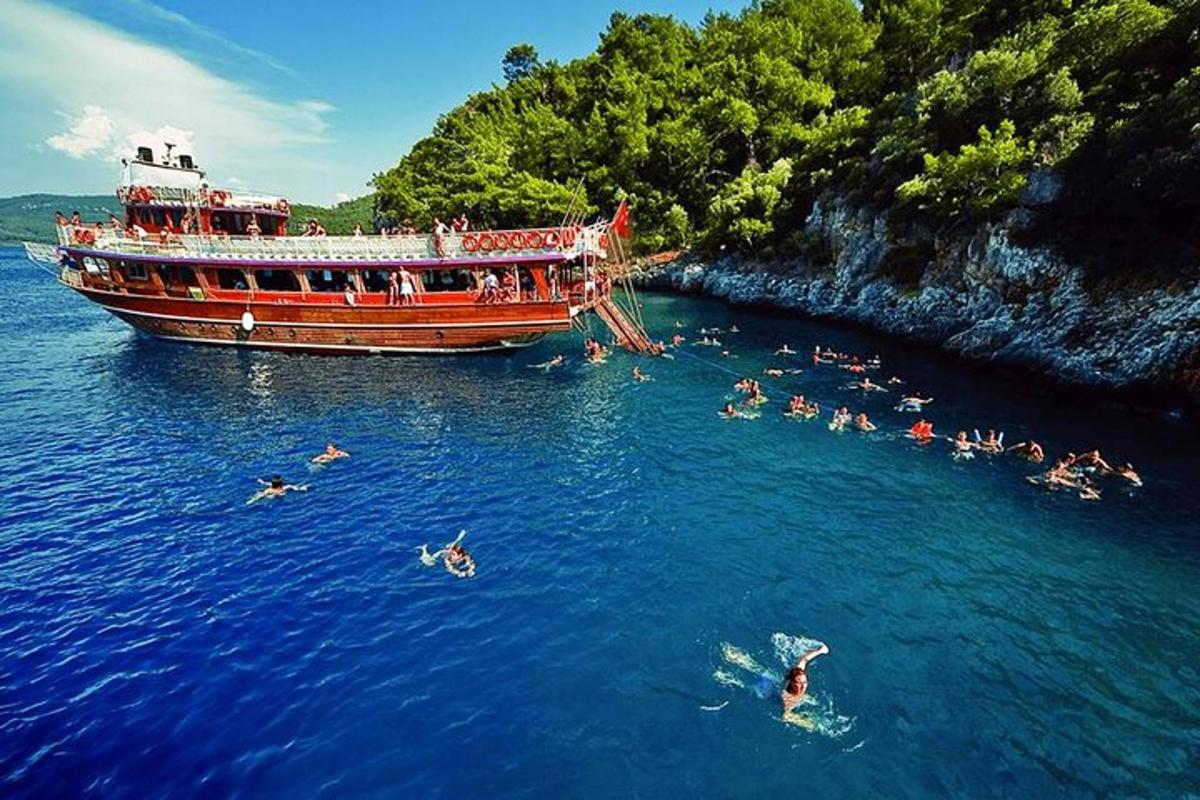 a group of people swimming in the water next to a boat
