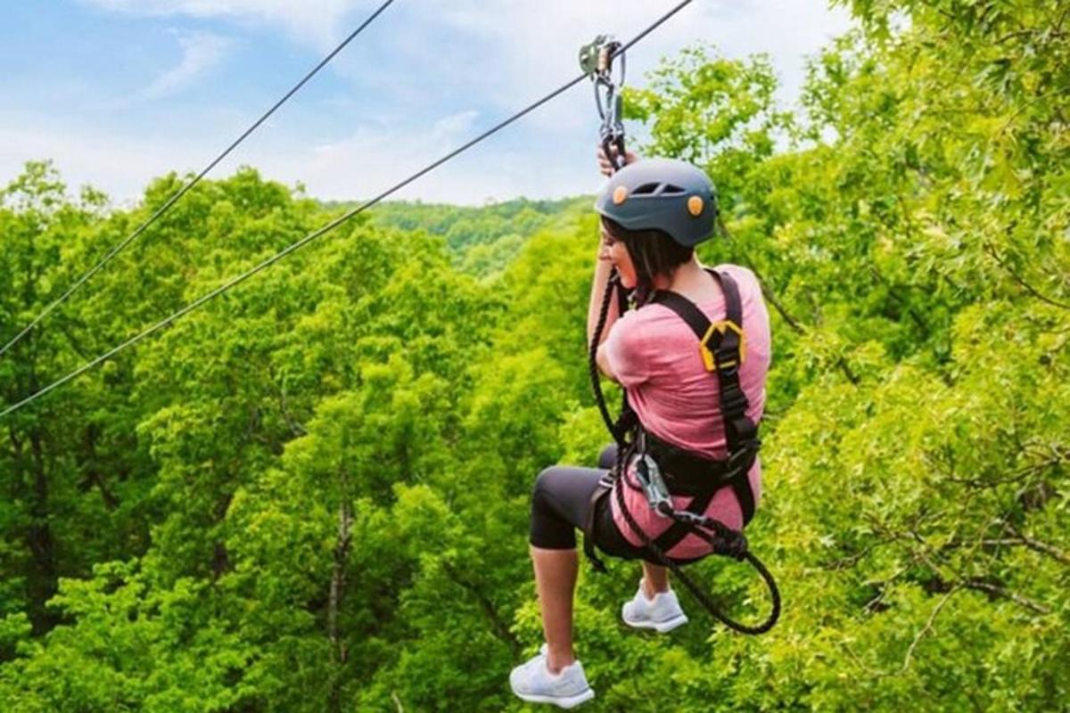 ženska v čeladi na ziplineu