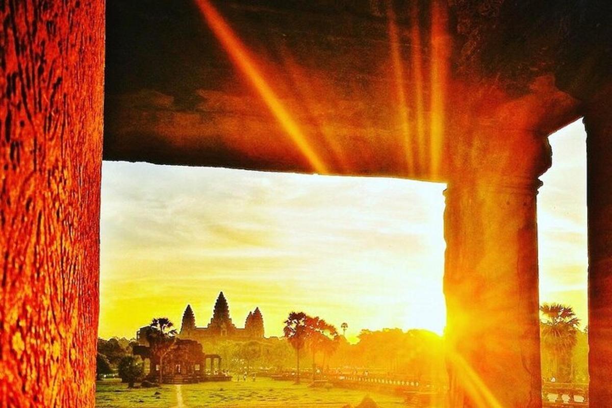 een uitzicht op een tempel vanuit een raam met de zonsondergang