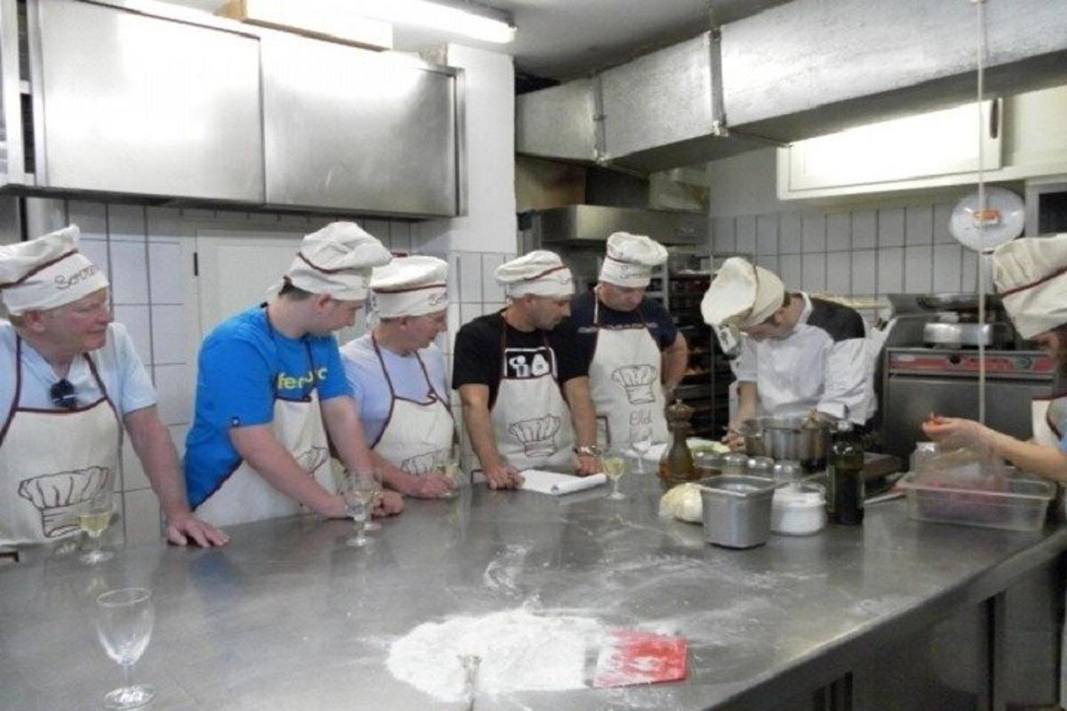 un grup de bucătari într-o bucătărie care pregătesc mâncare