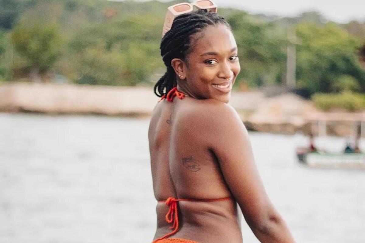 eine Frau im Bikini steht vor dem Wasser