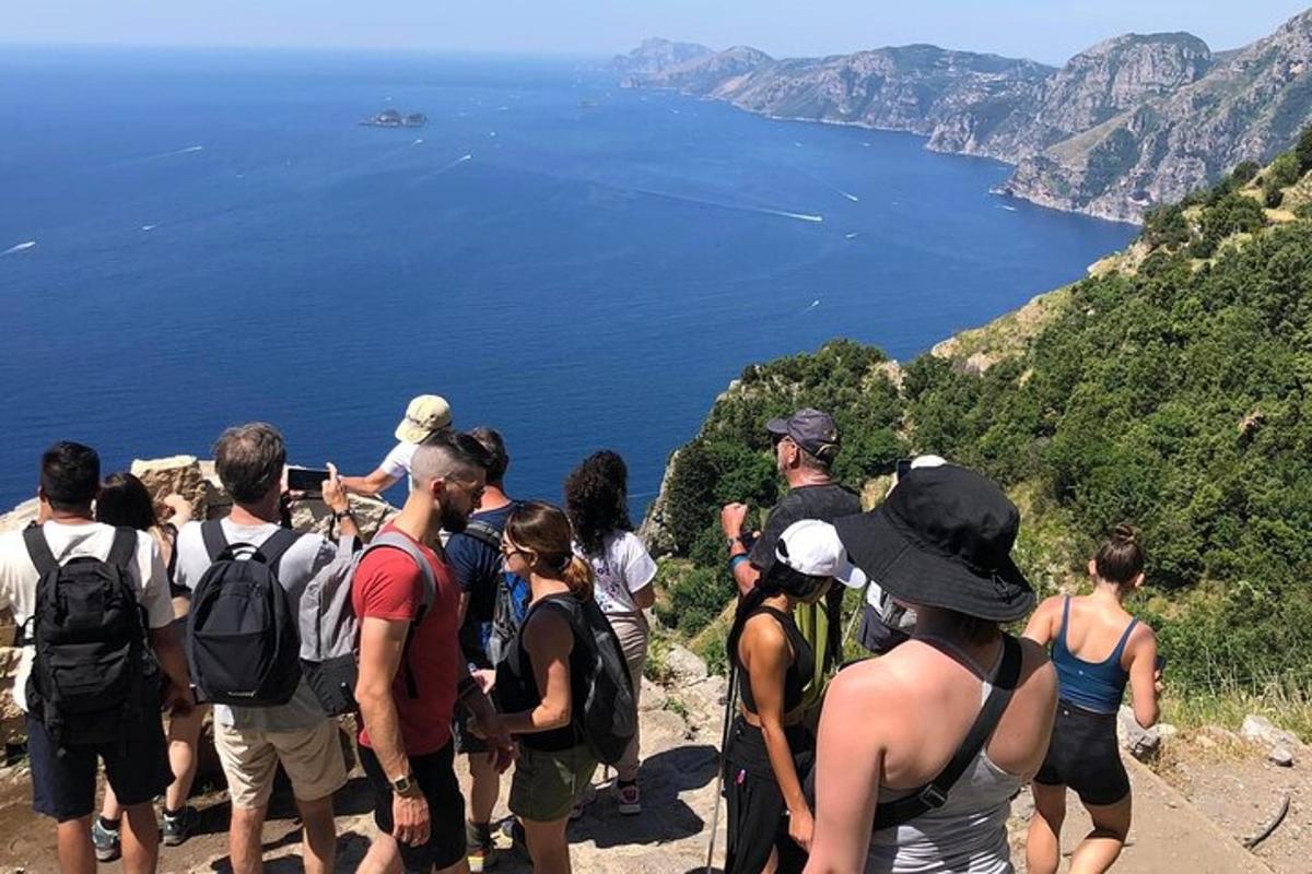 skupina lidí stojících na kopci a dívajících se na oceán