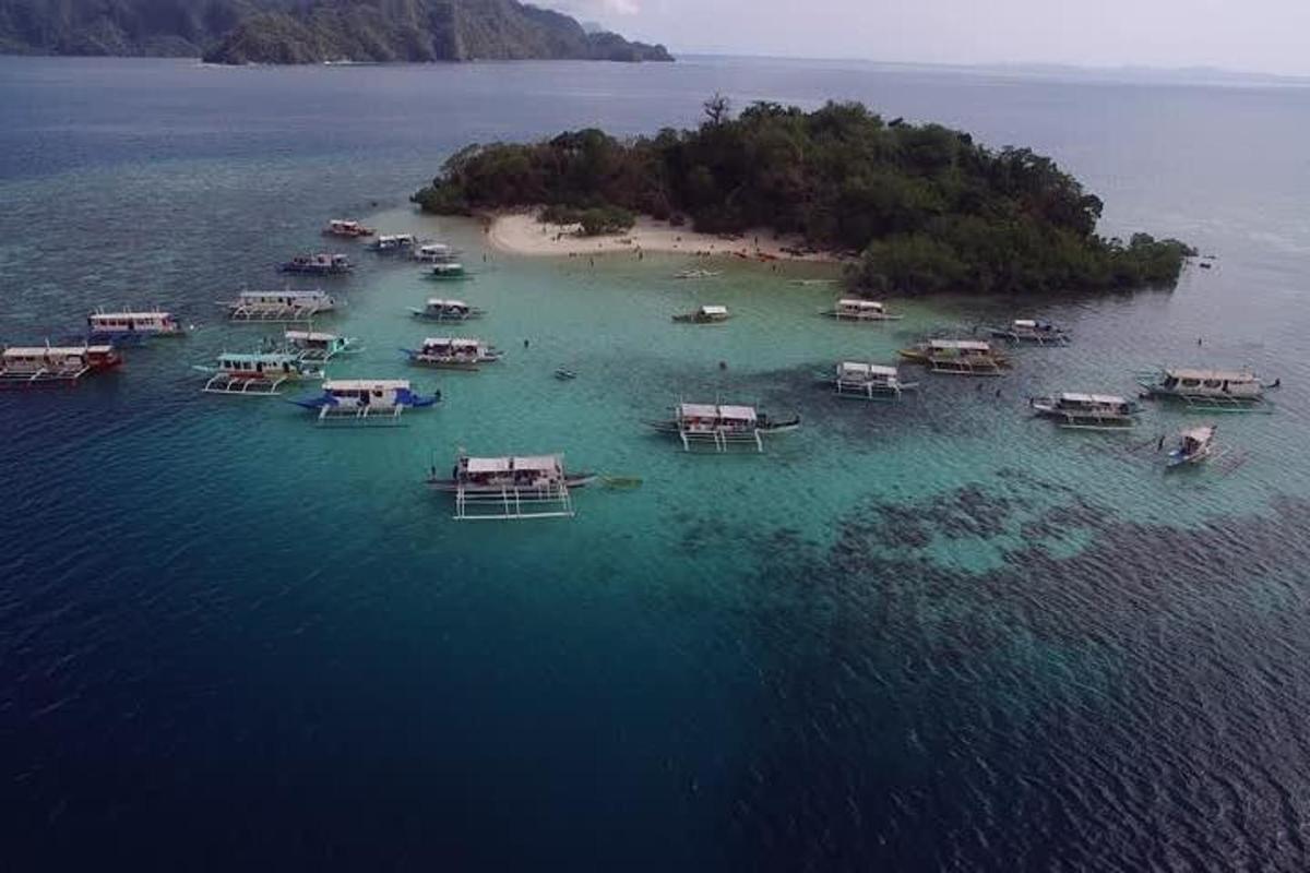 an aerial view of an island with boats in the water