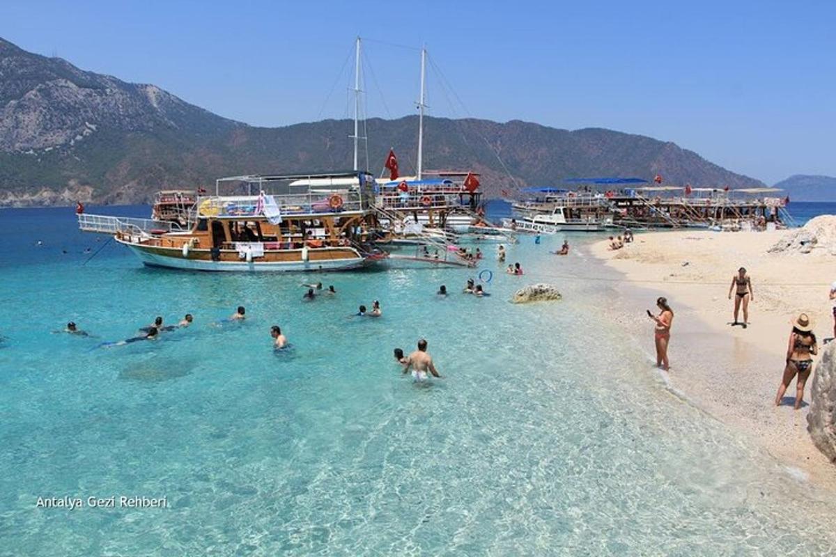 um grupo de pessoas na água em uma praia com barcos