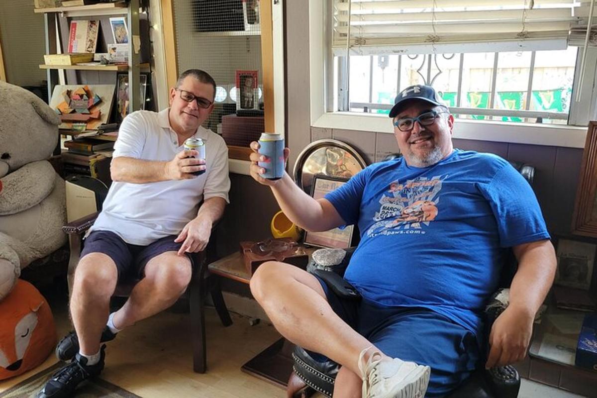 dva moška sedita v sobi in držita mobilni telefon