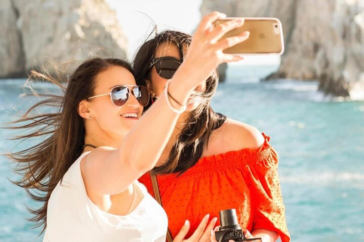 Δύο κορίτσια βγάζουν φωτογραφία τον ωκεανό με κινητό τηλέφωνο
