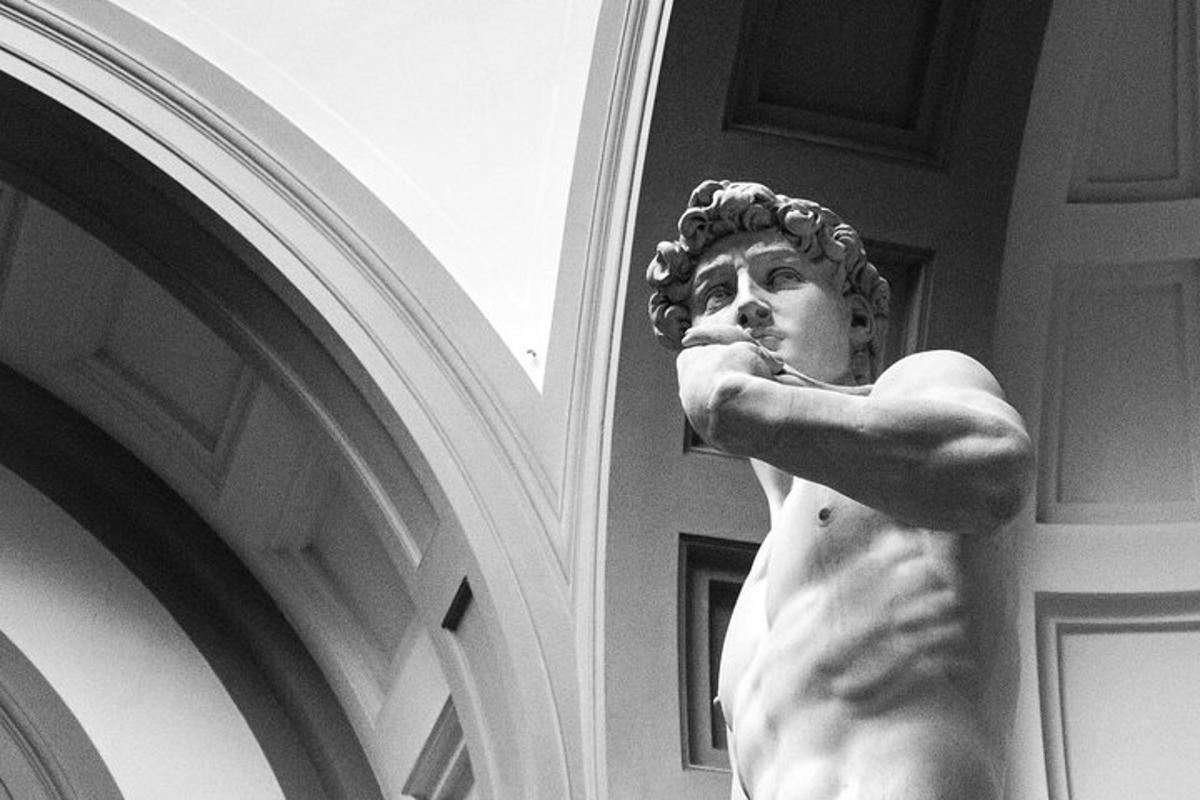 una statua di un uomo in piedi accanto a un edificio