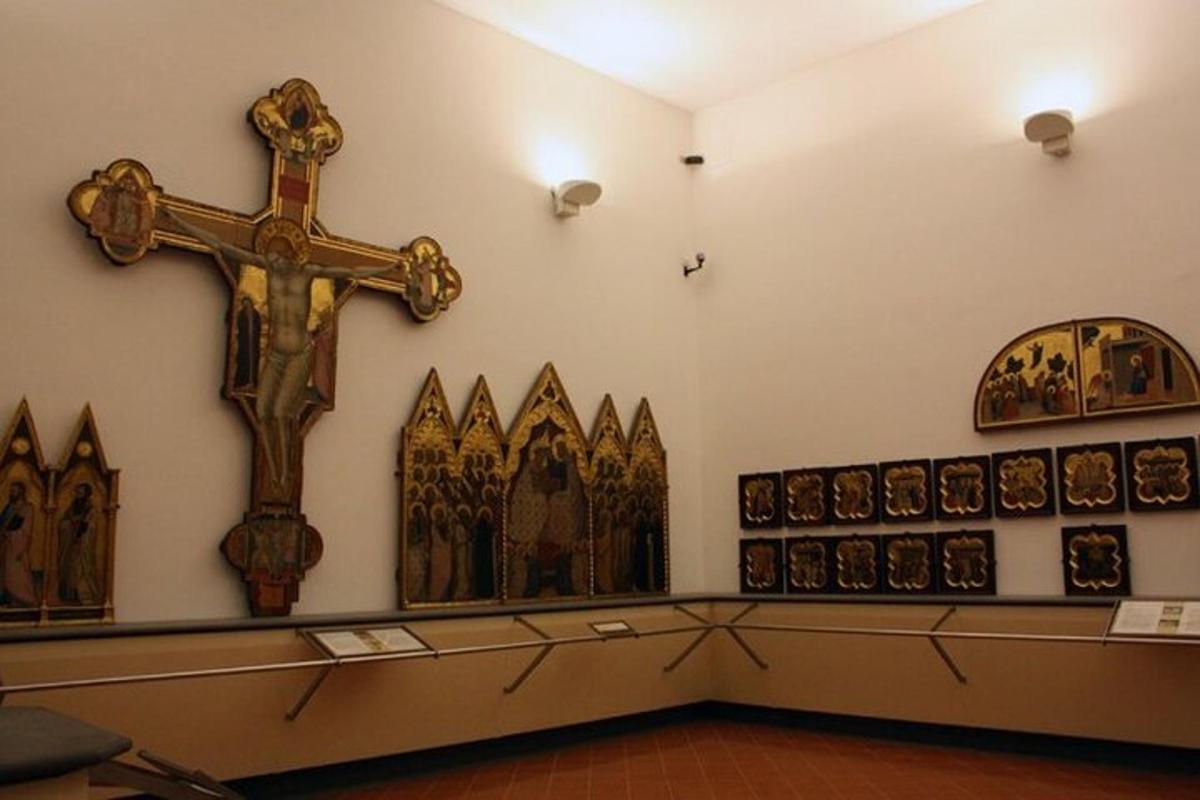 una croce sul muro di una chiesa con delle immagini