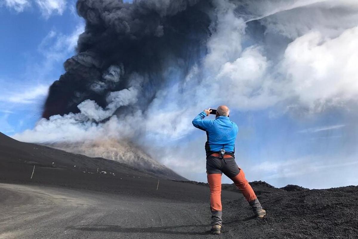a man taking a picture of a volcano