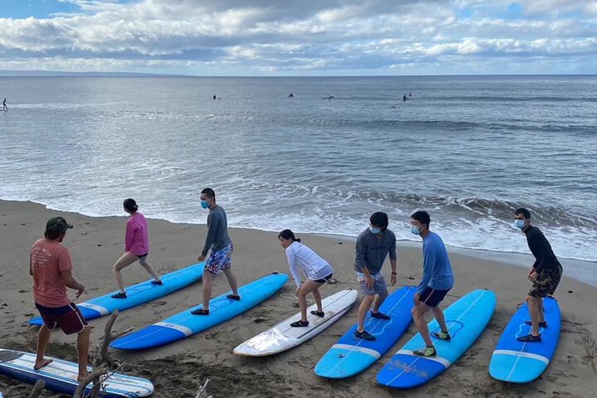 um grupo de pessoas em pé em pranchas de surfe na praia