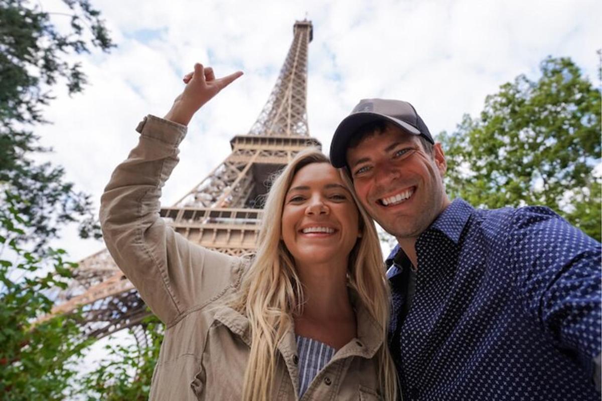 a man and a woman standing in front of the eiffel tower