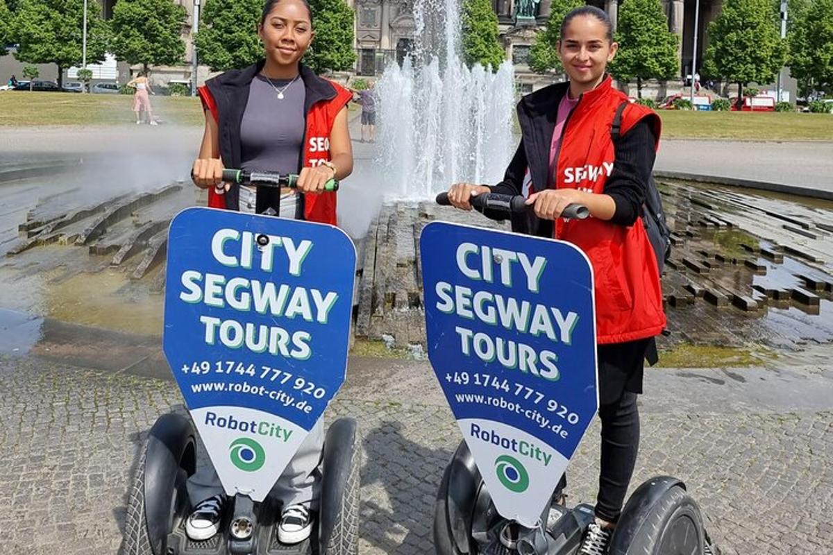 Dos mujeres en segways frente a una fuente