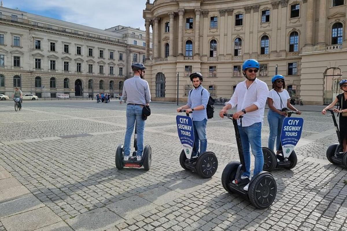 grupp inimesi, kes sõidavad hoone ees segwaydega