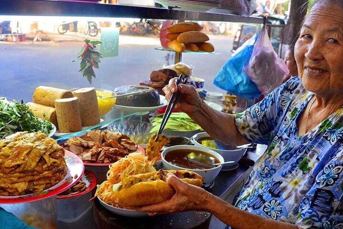 een oudere vrouw houdt een bord met eten vast