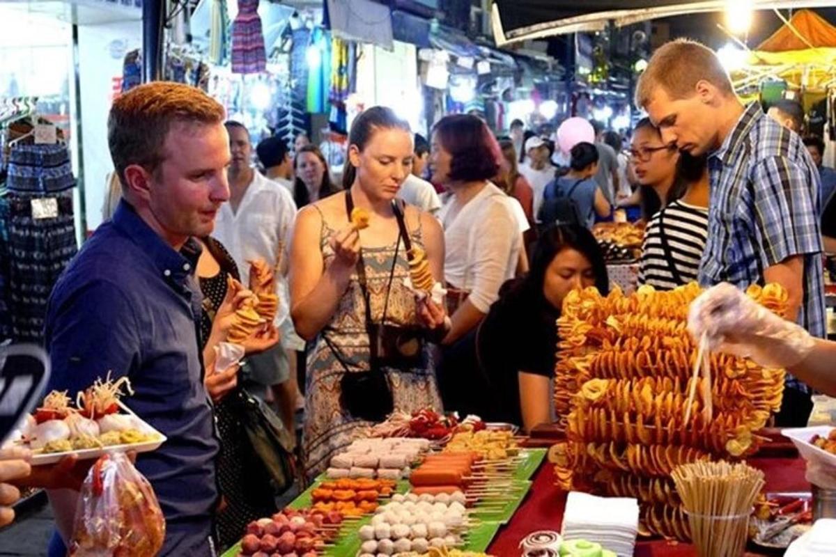 een groep mensen die rond een markt staan met eten