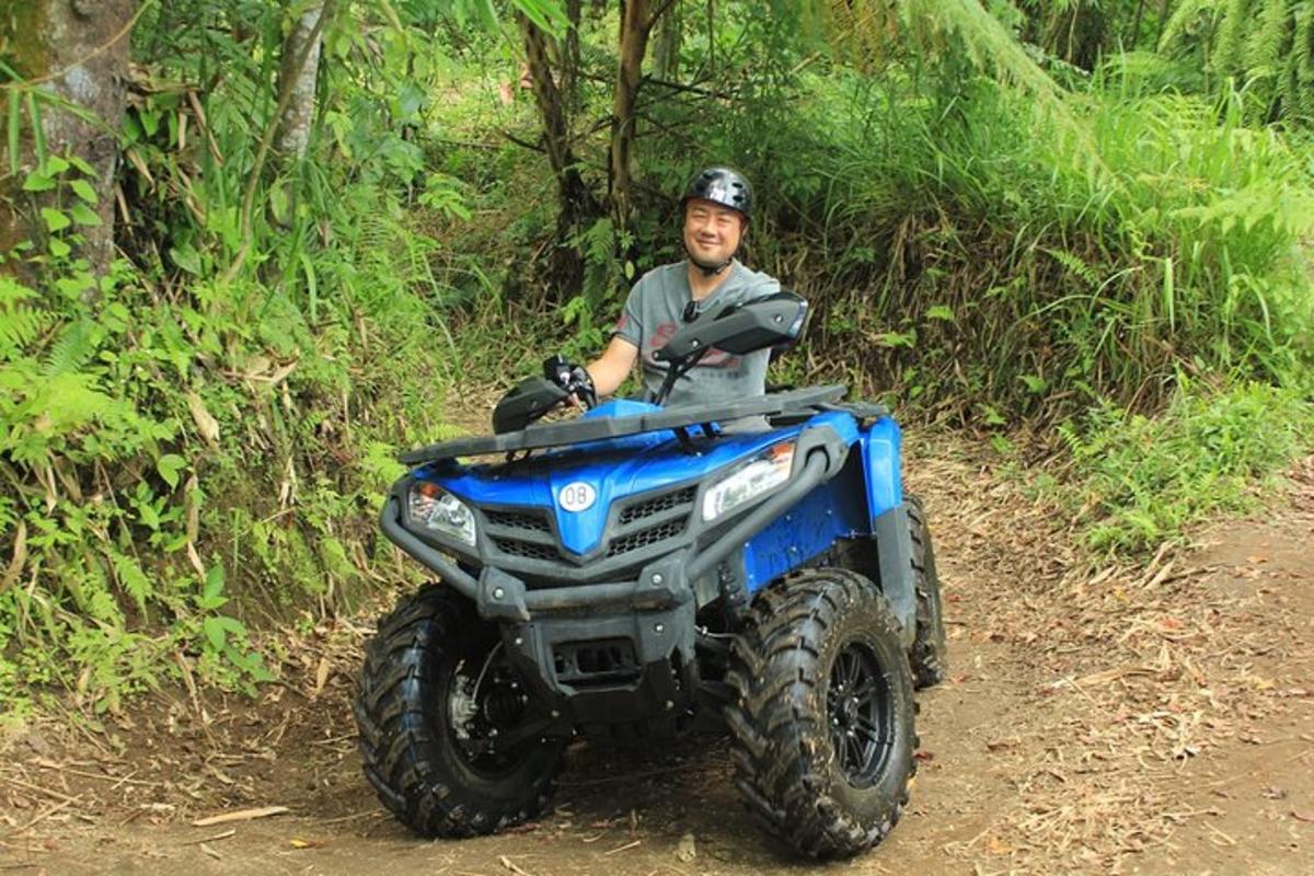 en mann som kjører en ATV nedover en grusvei