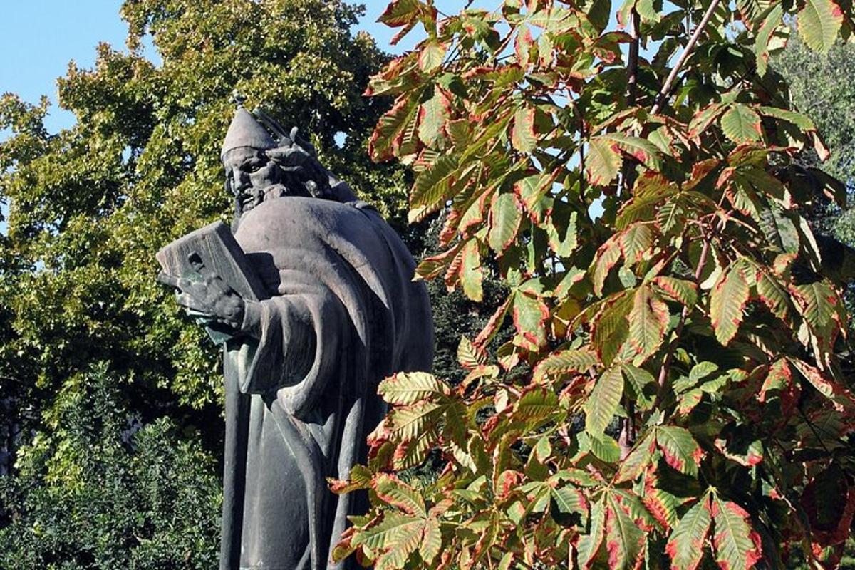 en staty framför ett träd med löv