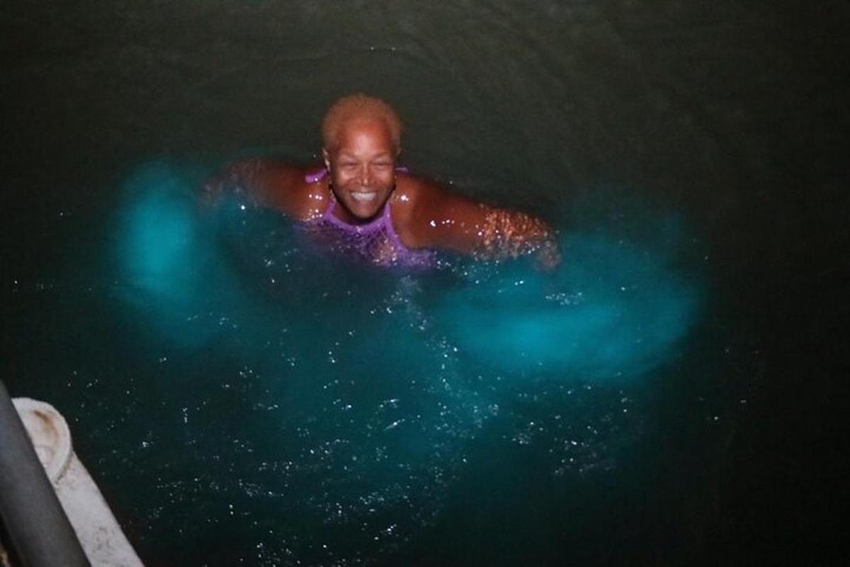 un hombre nadando en el agua por la noche