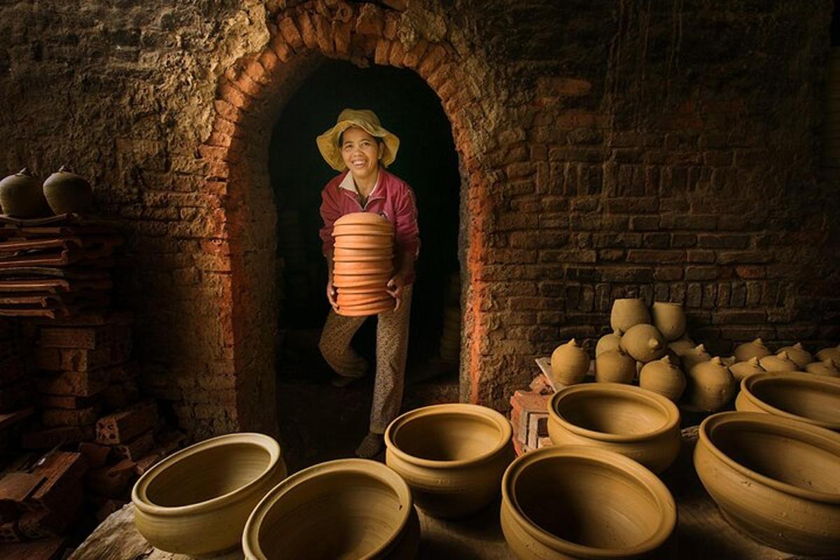 una donna tiene in mano una pila di ceramiche