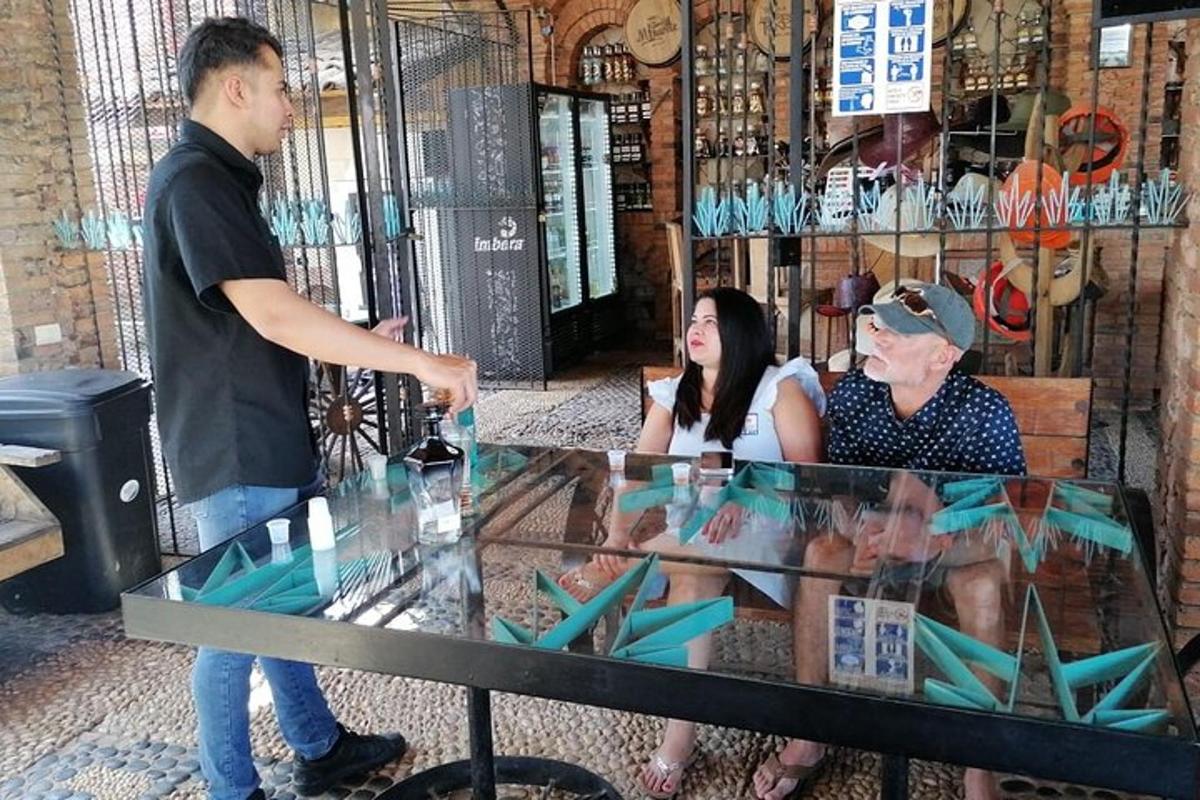 رجل يقف أمام طاولة زجاجية مع شخصين