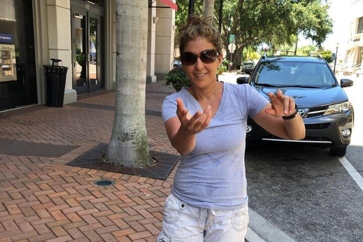 žena stojí na ulici s rukama v ruce