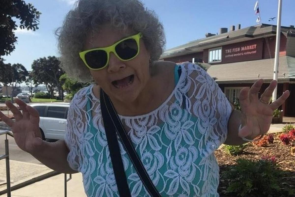 una donna che indossa occhiali da sole gialli in piedi davanti a un edificio