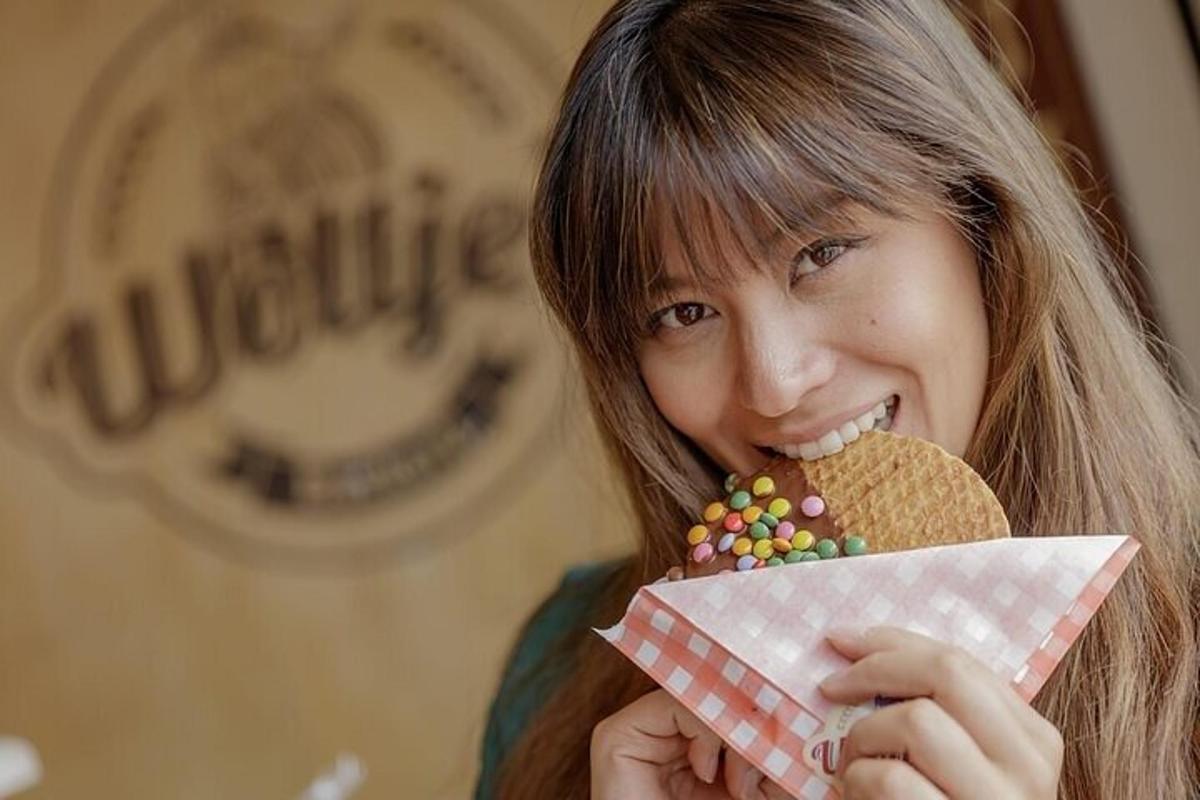 seorang gadis muda sedang makan biskut dan memegang sekotak donat