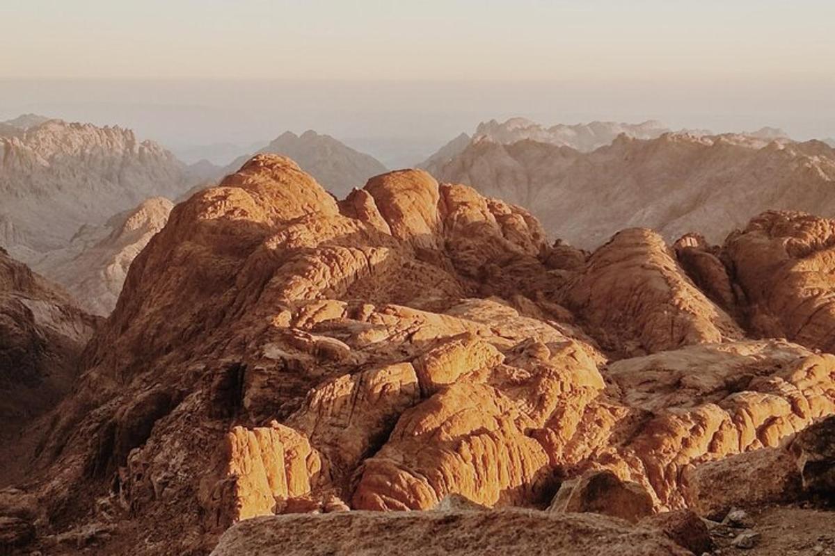 en vy över ett klippigt berg med berg i bakgrunden