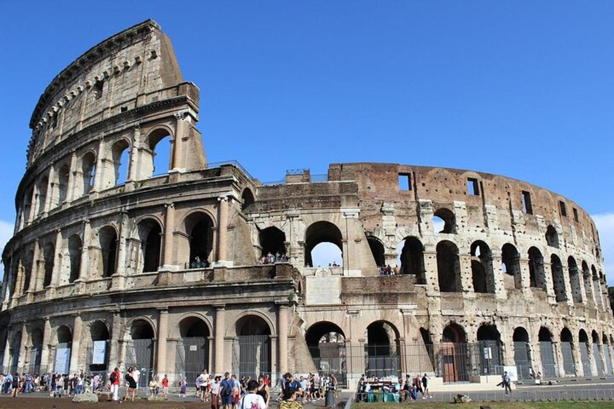 a group of people standing in front of the coliseum