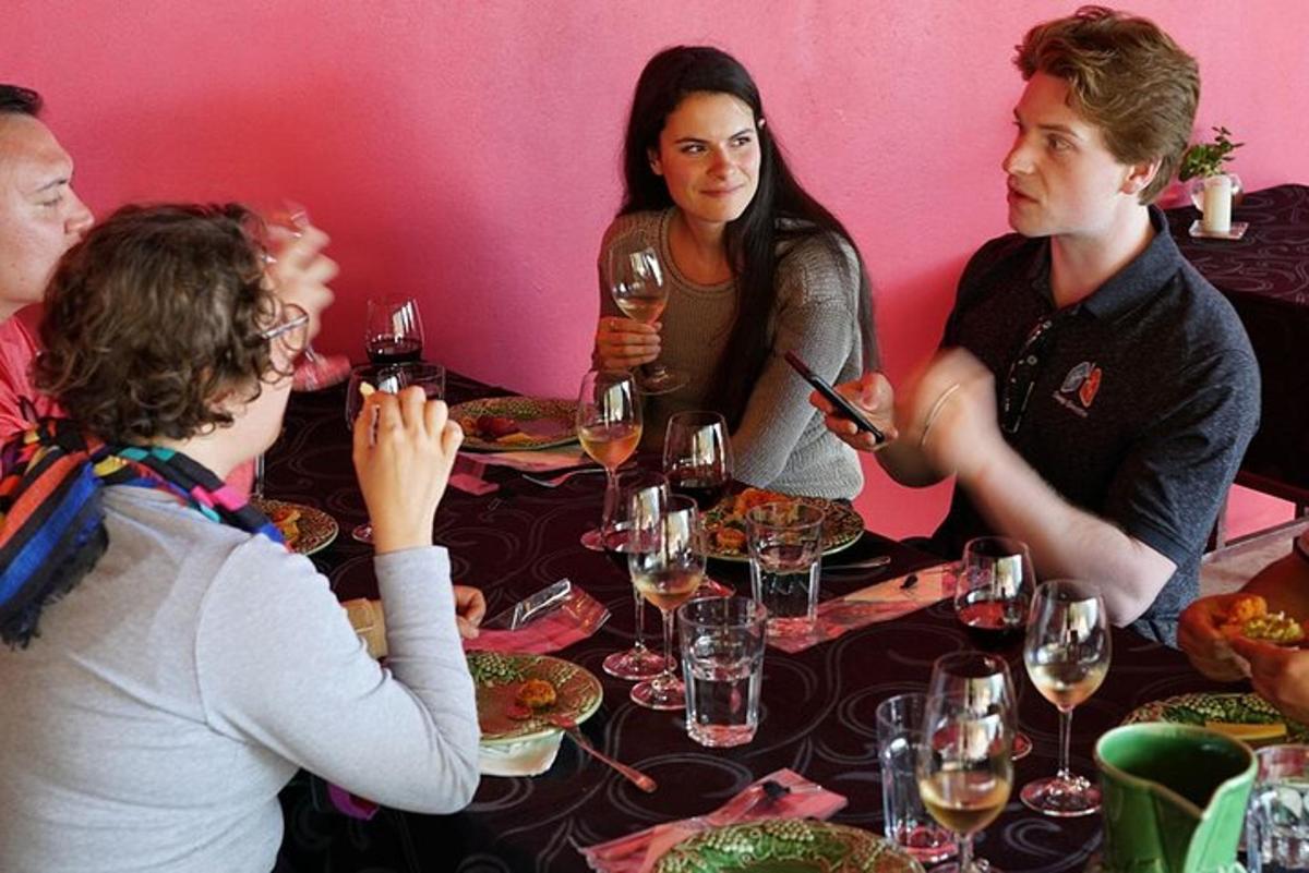 skupina lidí sedících kolem stolu s vinnými sklenicemi