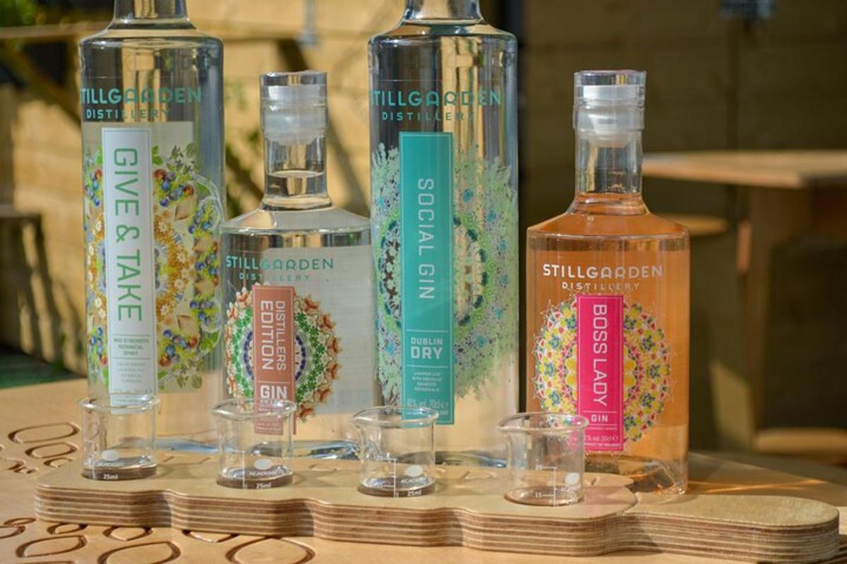 trzy butelki whisky stojące na stole z kieliszkami