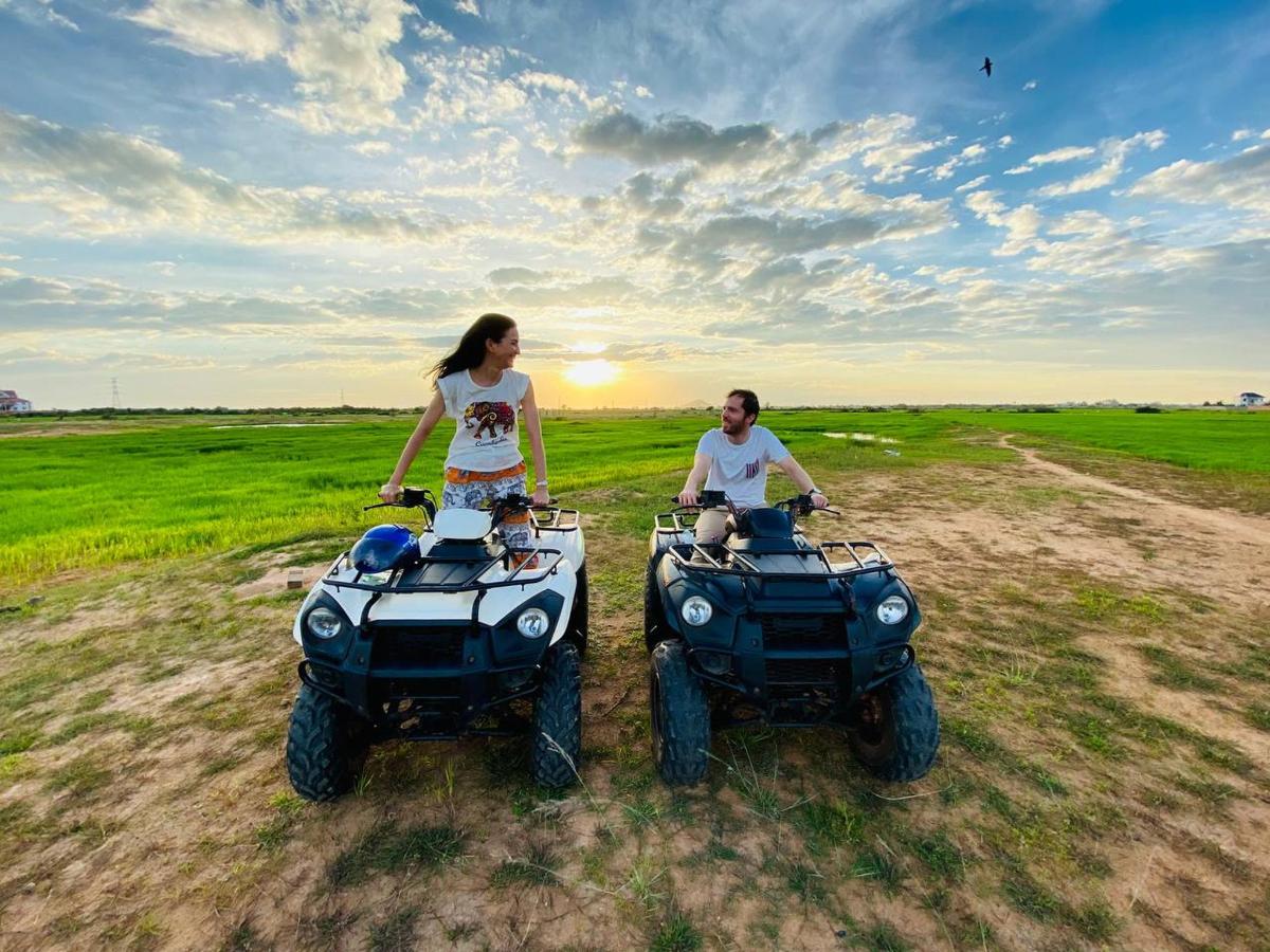 a man and a woman standing next to two atvs