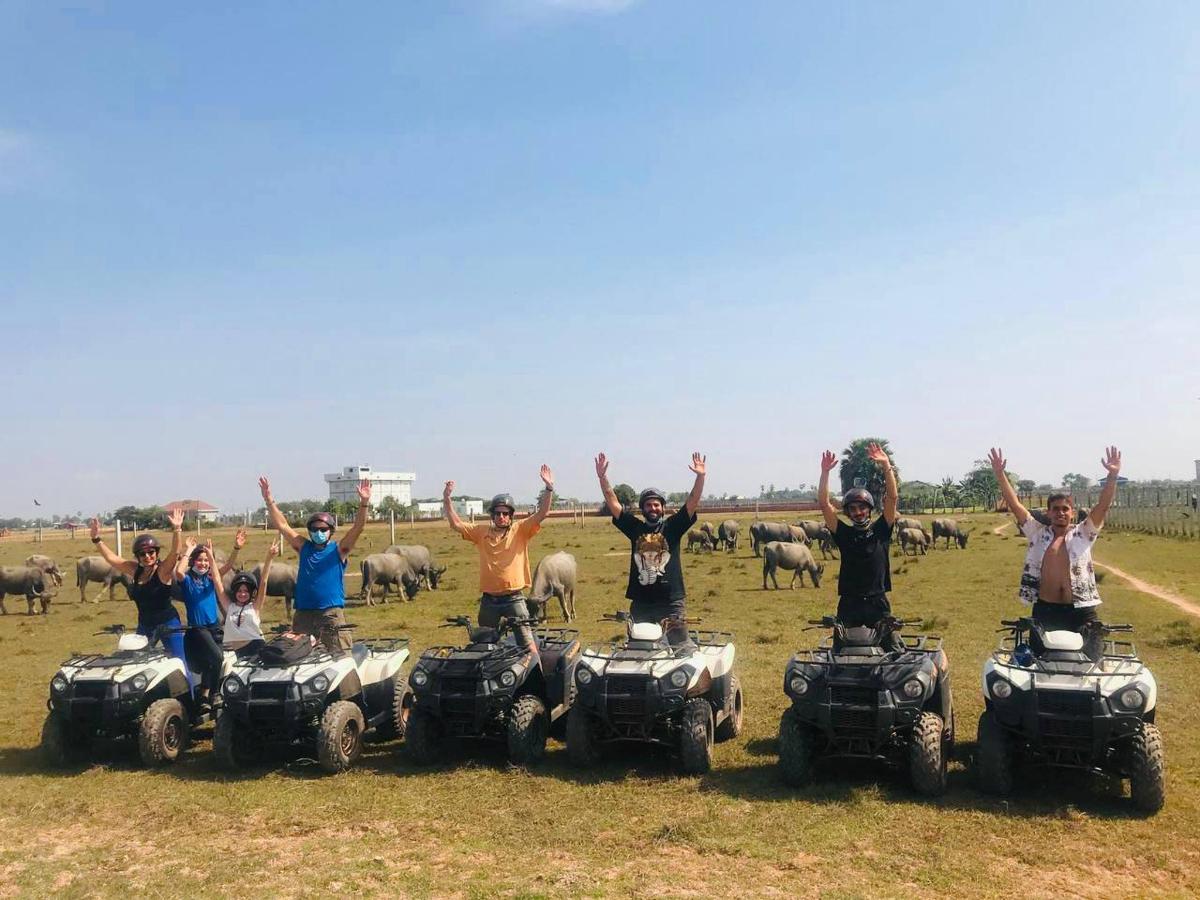 a group of people on atvs in a field with sheep