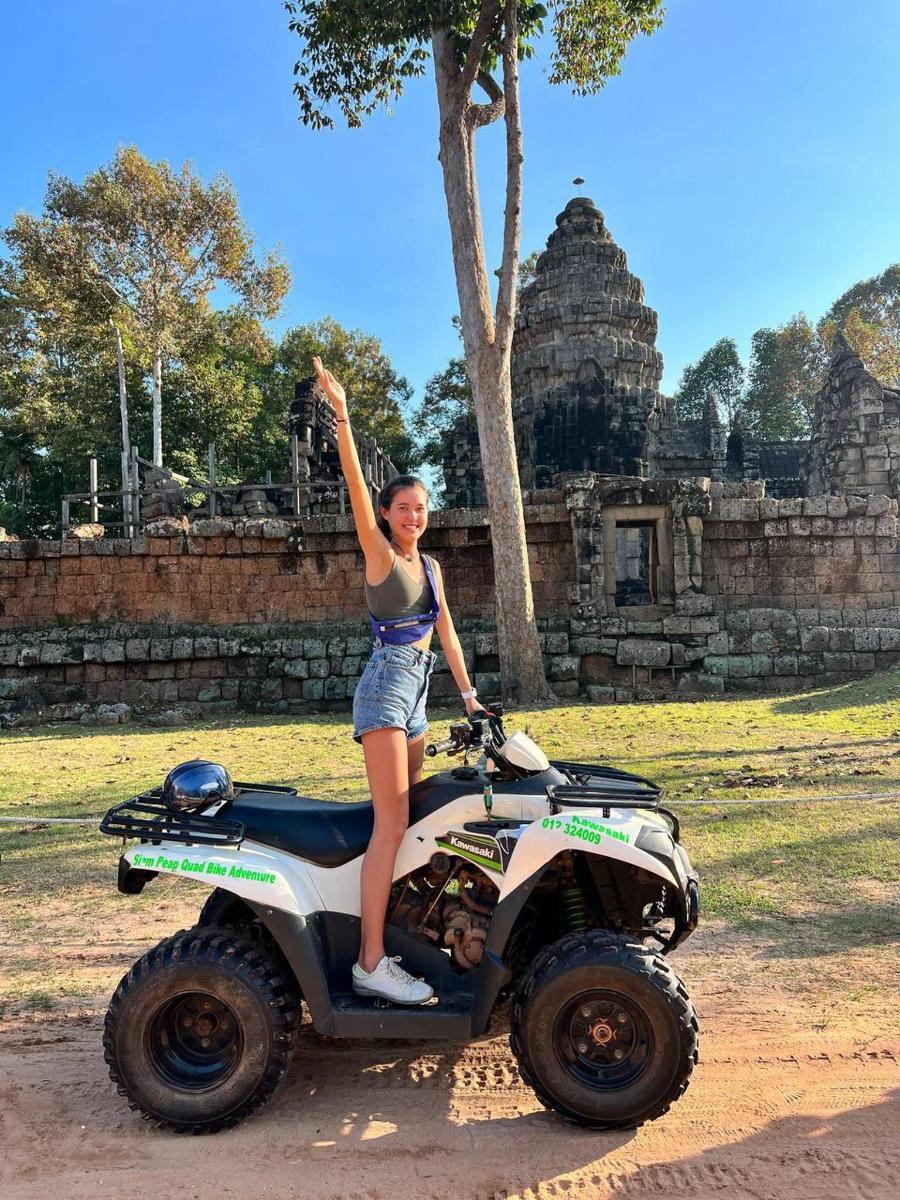 a woman standing on a atv with her arm in the air