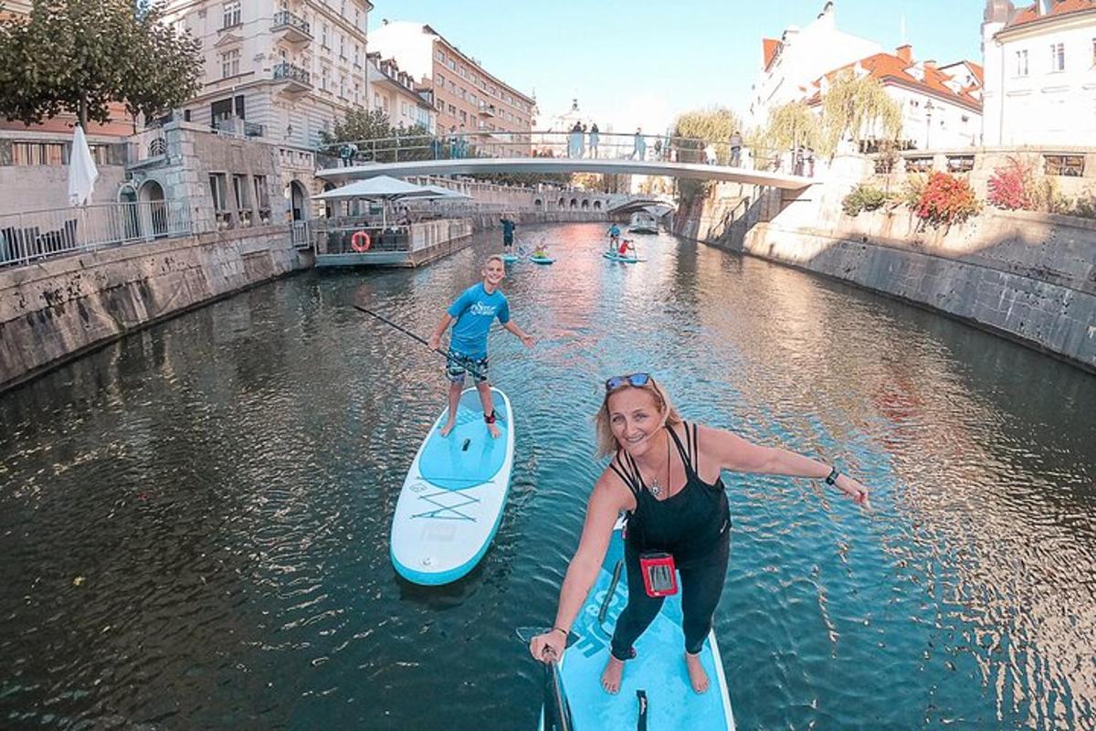 Dva lidé stojí na paddleboardech v řece