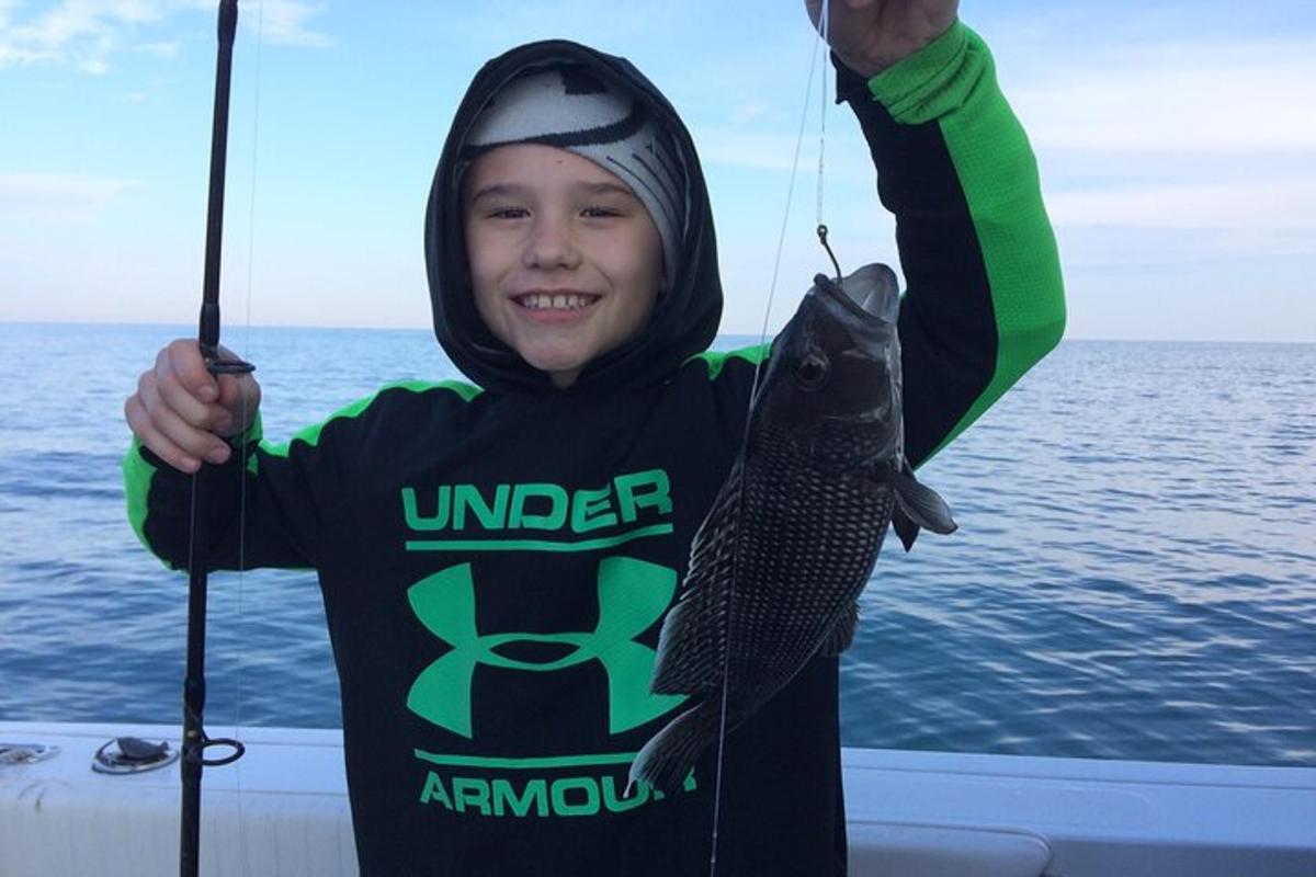 a young boy holding a fish on a boat