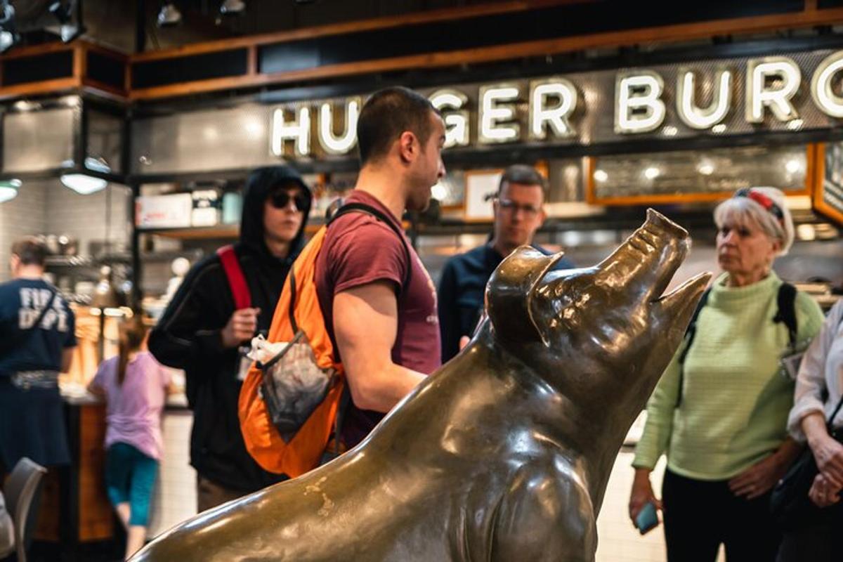 um homem em pé ao lado de uma estátua de um cachorro