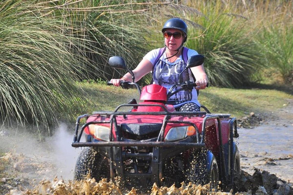 un home conduint un quad per l'aigua