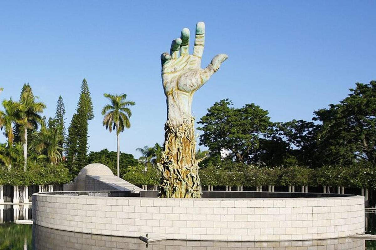 una statua di una mano che si allunga su un muro di mattoni