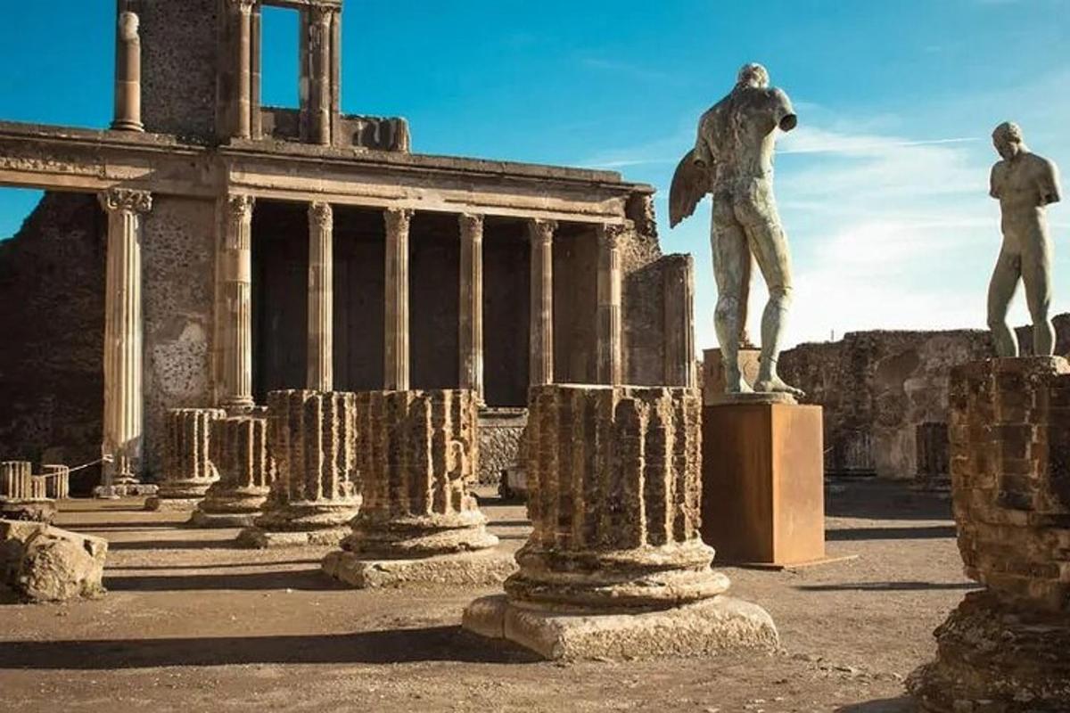 vīrieša statuja uz pjedestāla ēkas priekšā