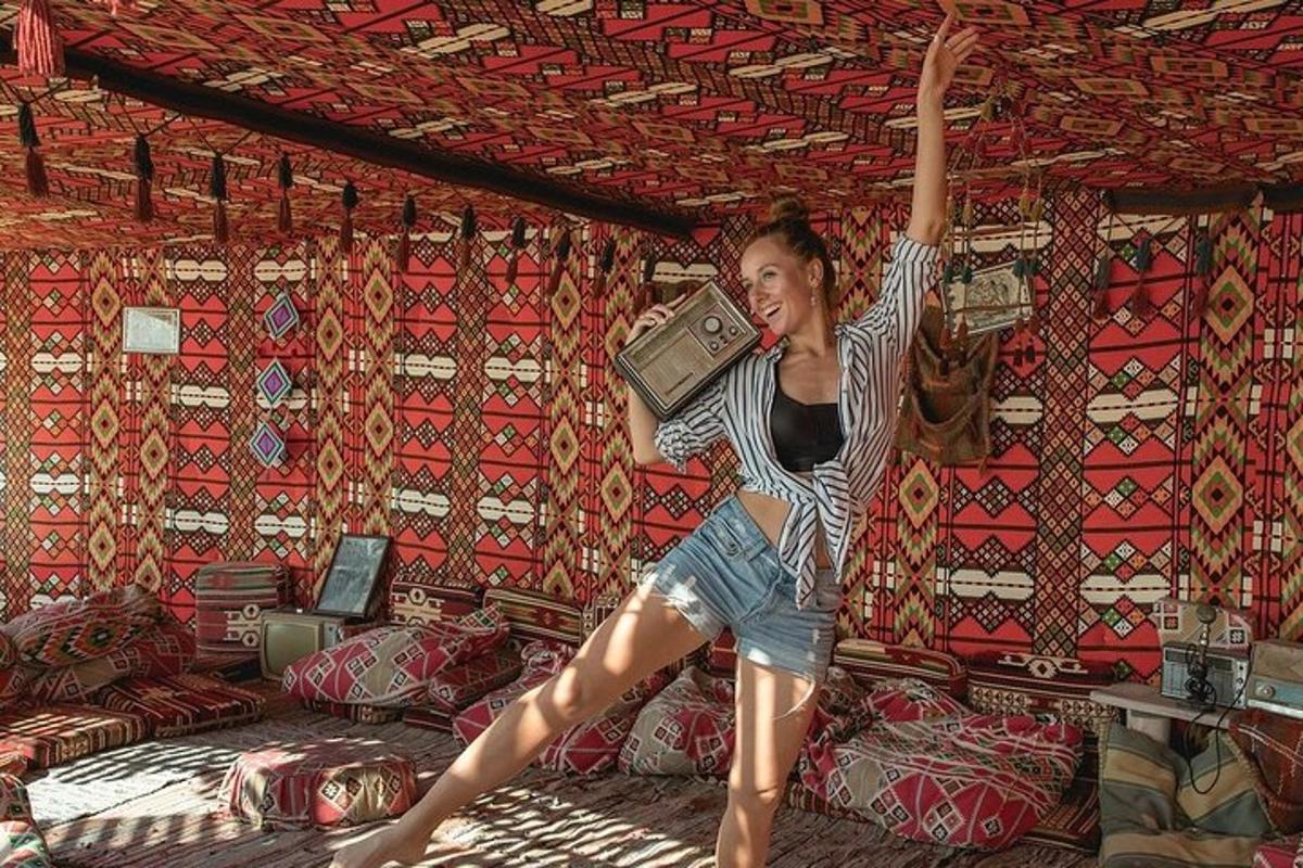 eine Frau springt mit einem Koffer in ein Bett