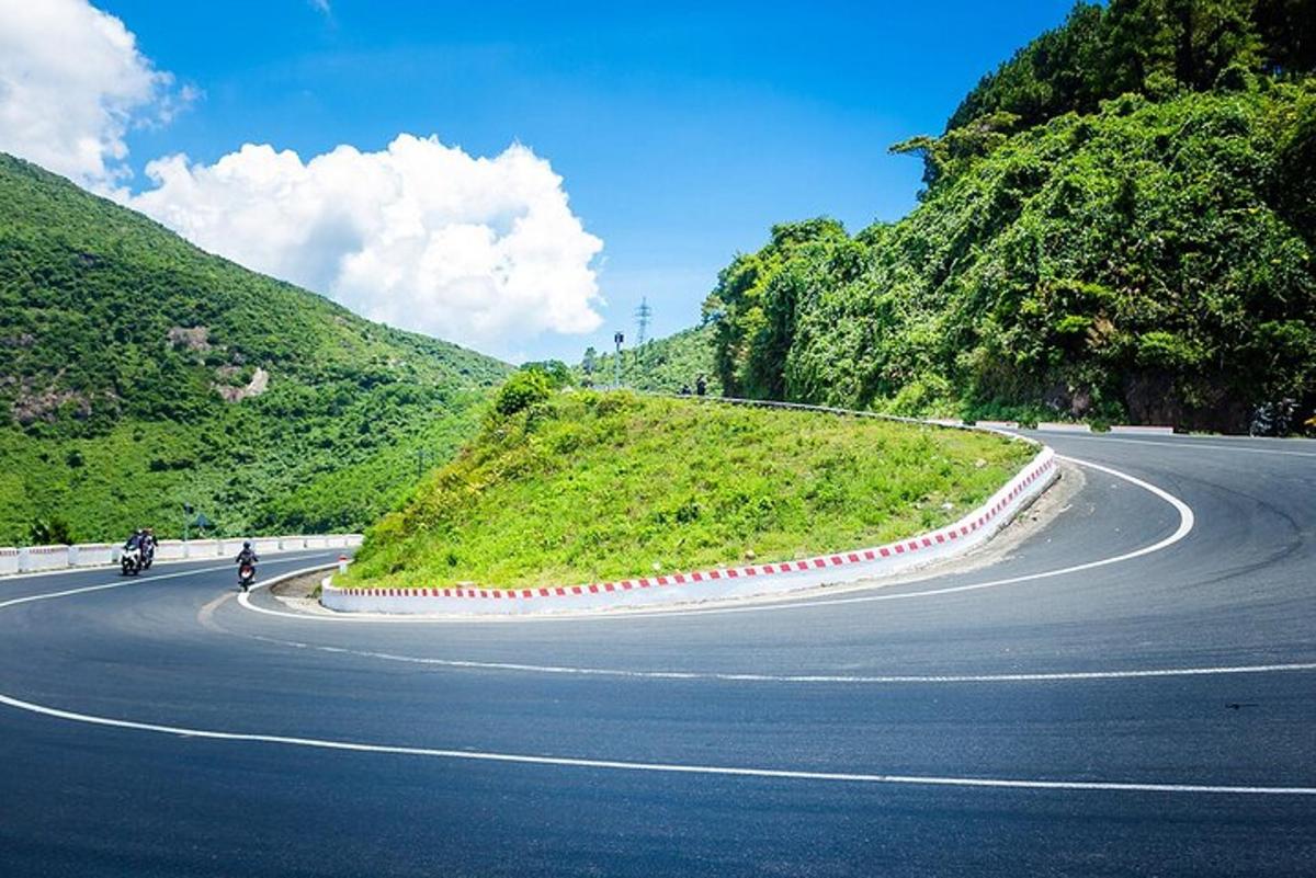 eine kurvenreiche Straße auf einem Hügel mit Motorrädern darauf