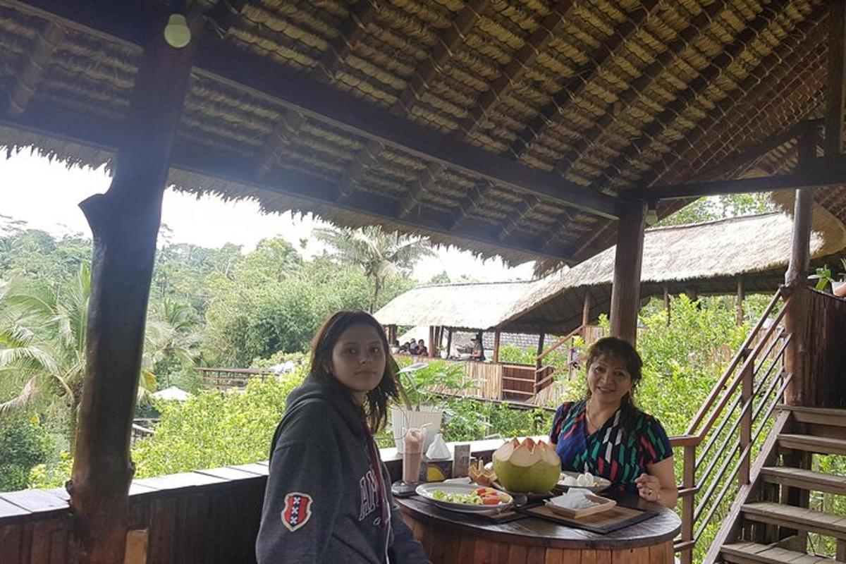 duas mulheres sentadas à mesa com uma refeição