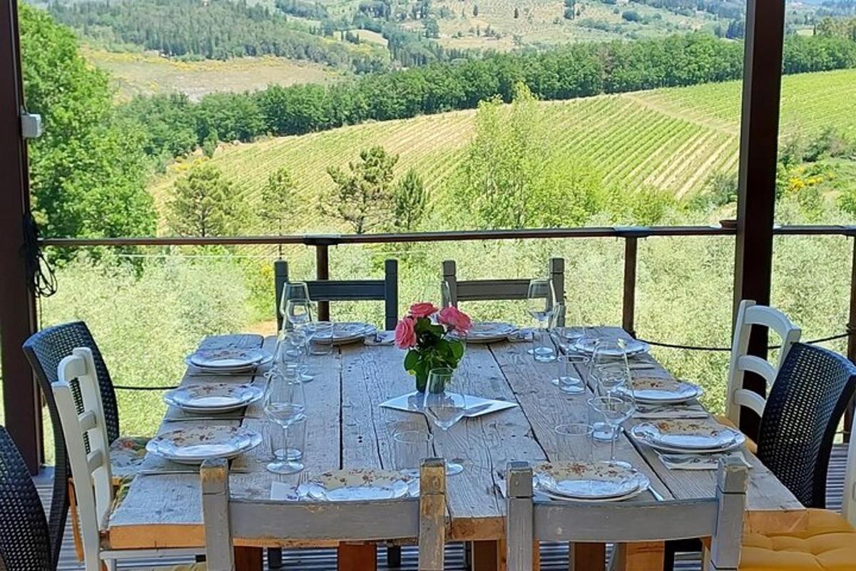 Una mesa con vasos y un jarrón con flores encima.