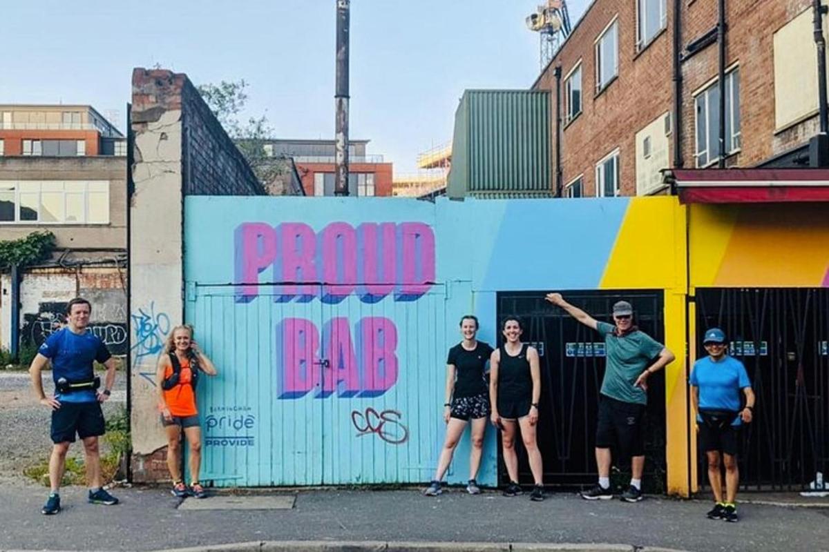 um grupo de pessoas em pé em frente a um muro com grafite