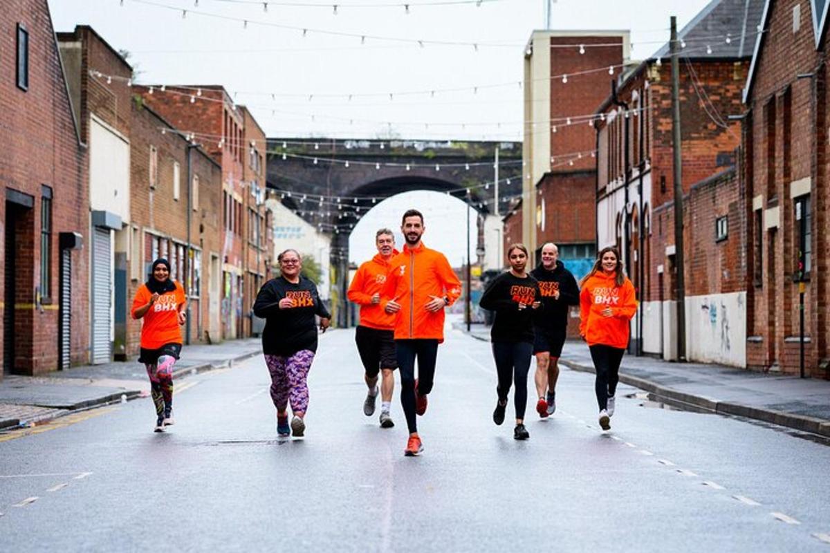 a group of people in orange shirts running down a street