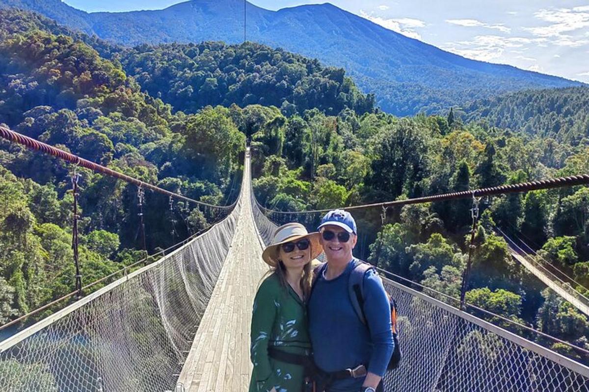 a man and woman standing on a suspension bridge